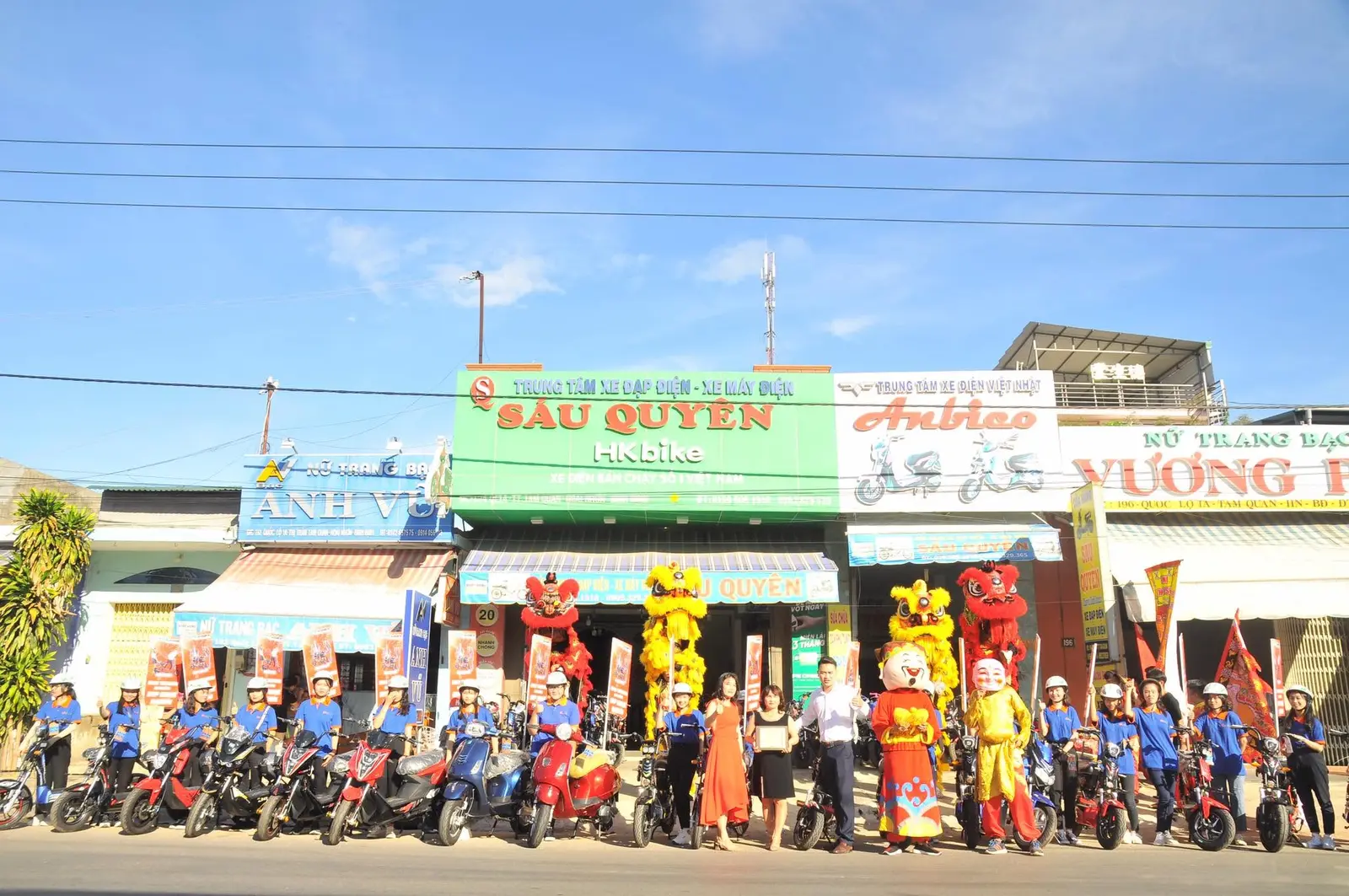 On-site photograph: Promotional team and electric bikes at Sau Quyen dealership.